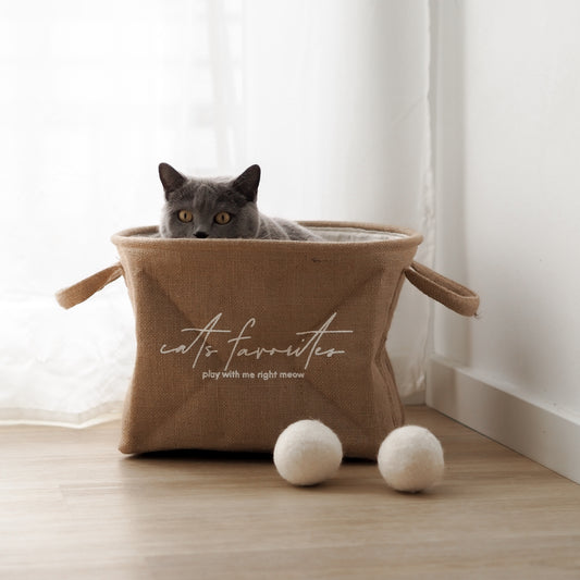 Katze sitzt in Aufbewahrung für Katzenspielzeug aus Jutestoff