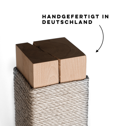 Eine Nahaufnahme einer Echtholz Kratzsäule für Katzen mit grauem Sisalseil und dem Schriftzug „Handgefertigt in Deutschland“.