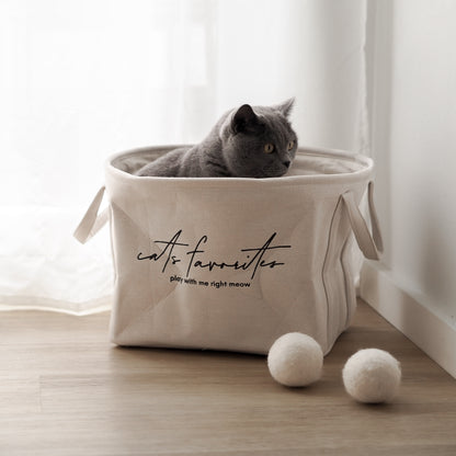 Katze sitzt in schönem Korb aus Leinenstoff für Katzenspielzeug