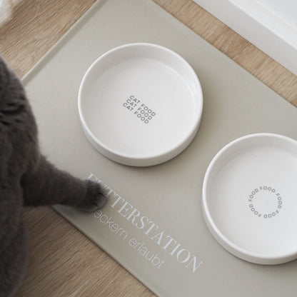 Flacher Katzennapf aus Keramik steht auf beiger Napfunterlage für Katzen