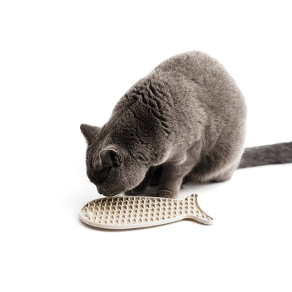 Eine Katze schleckt an einer beigen Schleckmatte.