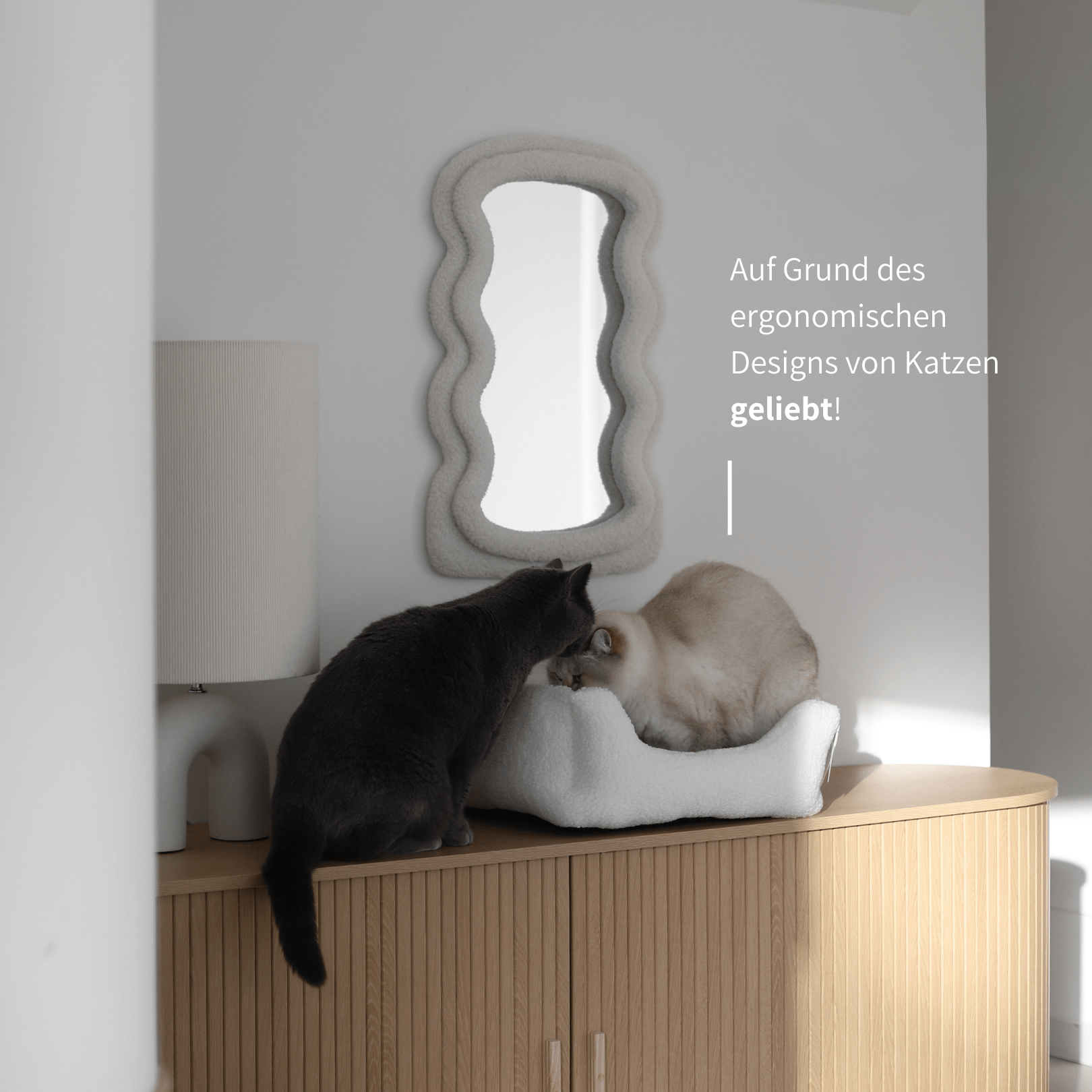 Ergonmisches Katzenbett vor stilvoller Einrichtung mit zwei Hauskatzen