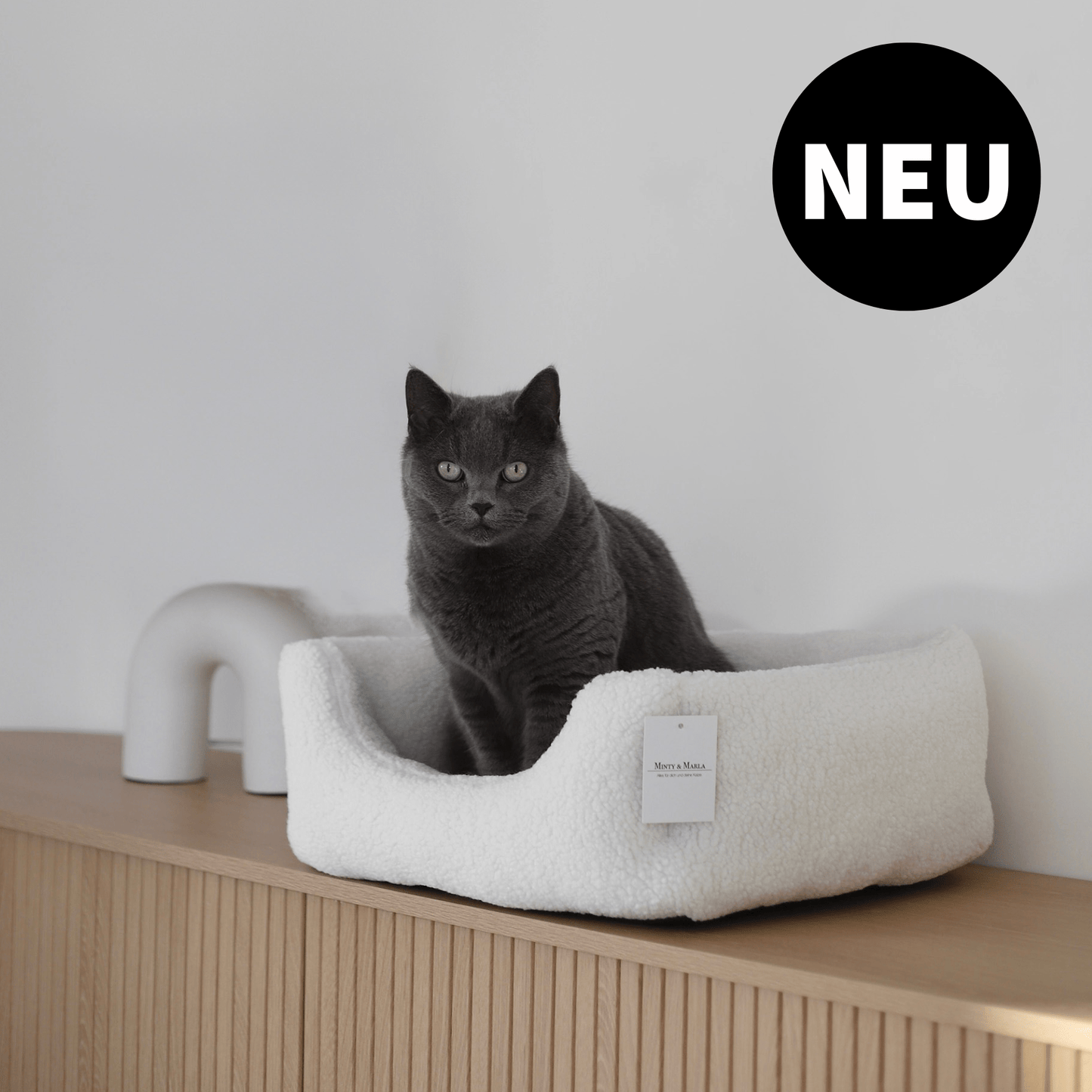 Katzenbett Schlafplatz für Katzen aus Teddystoff vor stilvoller Einrichtung