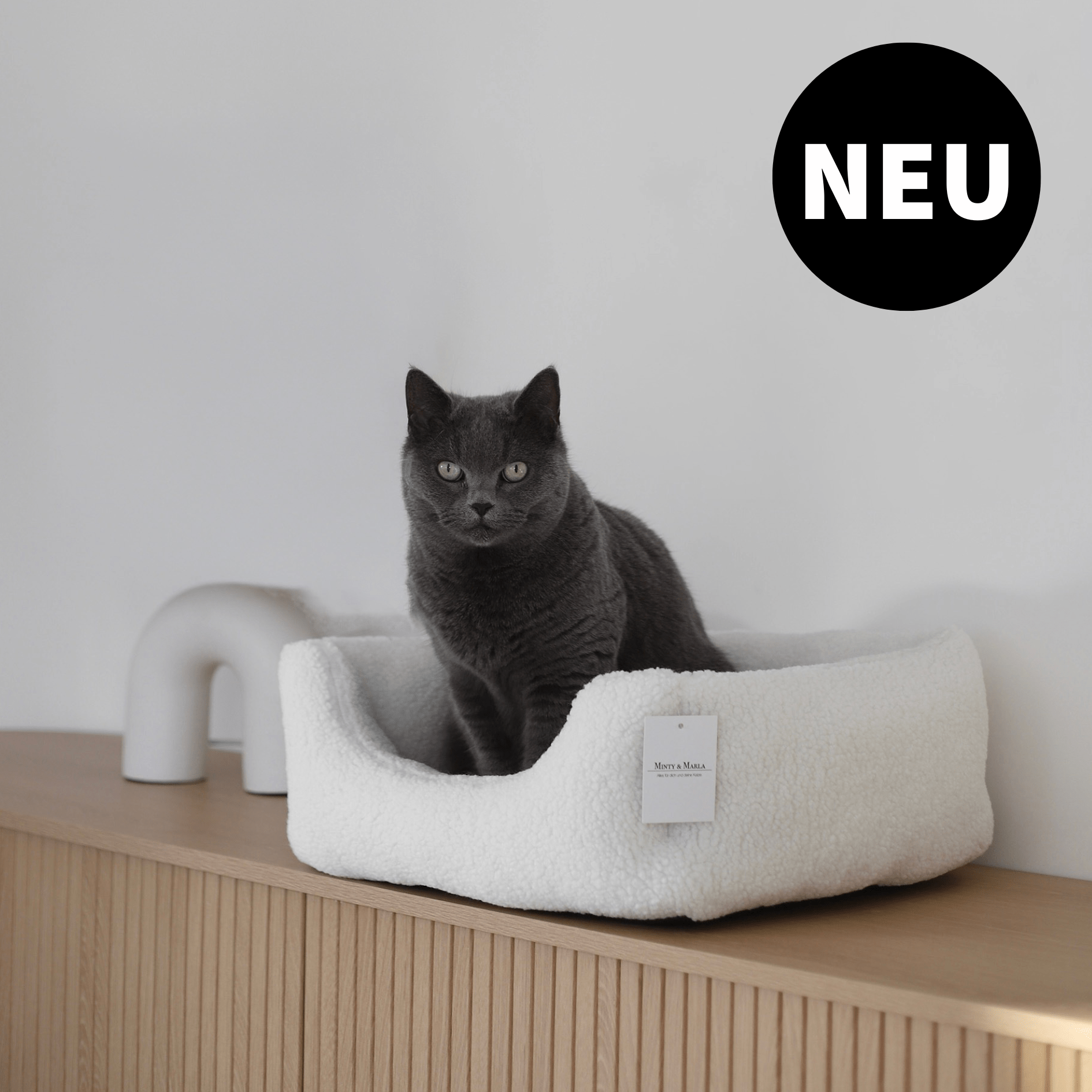 Katzenbett Schlafplatz für Katzen aus Teddystoff vor stilvoller Einrichtung